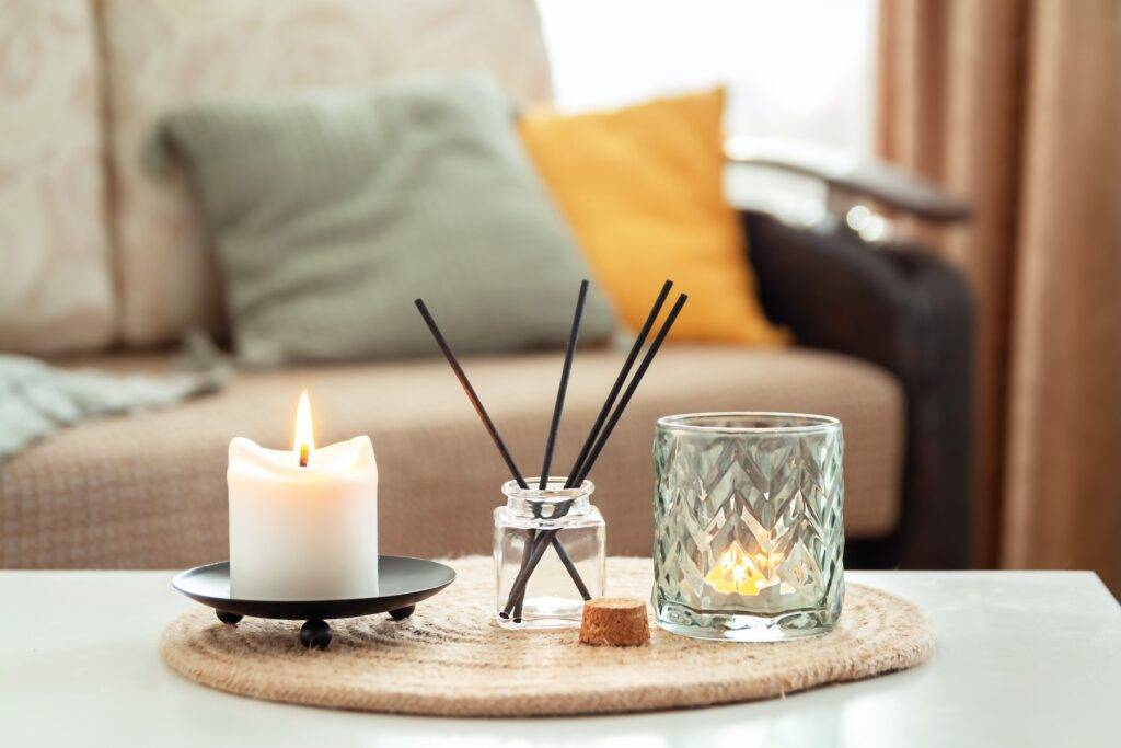 Scented candles and aroma incense sticks on table in living room aromatherapy home fragrance concept of home relaxation and anti stress